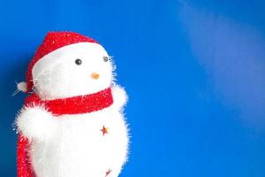jul bakgrund av snögubbe docka med en röd hatt och röd scarf. foto