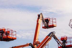 ledad bomlyft. plattformslyft. teleskopisk bomlyft mot blå himmel. mobil byggkran för uthyrning och försäljning. underhåll och reparation av hydraulisk bomlyft. kranhandlare. foto