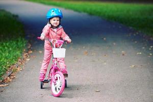 liten flicka med cykel foto