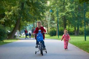 pojke och flicka med cykel foto