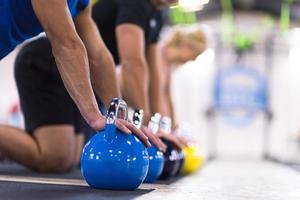 ung idrottare håller på med armhävningar med kettlebells foto