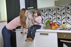 Lycklig dotter och mamma i kök foto