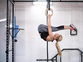 kvinna arbetssätt ut på gymnastiska ringar foto