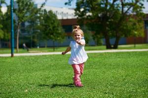 liten flicka ha roligt i parkera foto