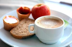 kopp cappuccino med frukt, yoghurt och bröd