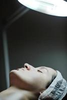 kvinna med ansiktsbehandling mask i kosmetisk studio foto