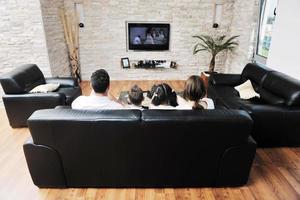 familj tittar på platt TV på modern Hem inomhus- foto