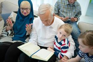 modern muslim farföräldrar med barnbarn läsning quran foto