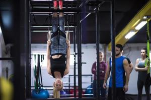 kvinna arbetssätt ut med personlig tränare på gymnastiska ringar foto