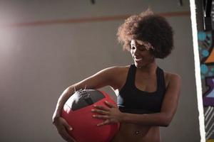 svart kvinna bärande crossfit boll foto