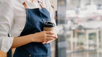 kaffe företag begrepp skön kvinna erbjudanden disponibel ta bort varm kaffe på de kaffe affär foto