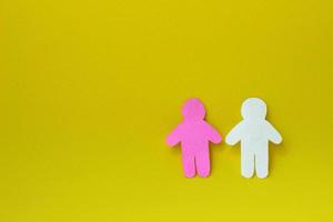 två silhuetter av en människor ristade från vit och rosa papper på gul bakgrund. på rätt sida av Foto med kopia Plats. begrepp av kommunikation, relationer, kärlek, lagarbete