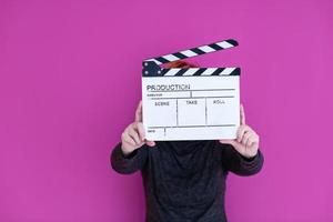 kvinna innehav film kläpp isolerat på rosa bakgrund foto