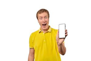leende ung man med smartphone attrapp i hand, vit isolerat bakgrund, mobil app annonsera foto