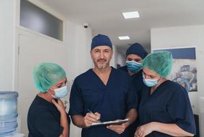 ortopedisk läkare arbetssätt tillsammans med hans multietnisk team foto