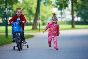 pojke och flicka med cykel foto