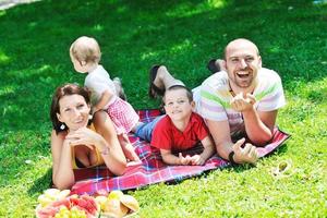 lyckliga unga par med sina barn ha kul på parken foto