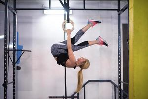 kvinna arbetssätt ut på gymnastiska ringar foto