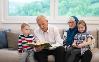 modern muslim farföräldrar med barnbarn läsning quran foto