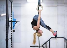 kvinna arbetssätt ut på gymnastiska ringar foto