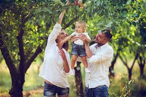 familjer med en barn i de sommar trädgård foto