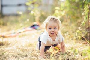 liten flicka krypande på de gräsmatta foto