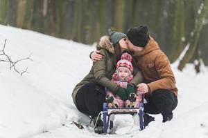 pappa och mamma med en liten dotter i de parkera foto