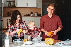 pappa, mamma och liten son laga mat en paj foto