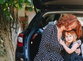 Lycklig kvinna Sammanträde med henne dotter i de bil foto