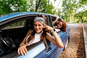 två flick lura runt om och skrattande tillsammans i en bil foto