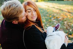 ung familj och nyfödd son i höst parkera foto