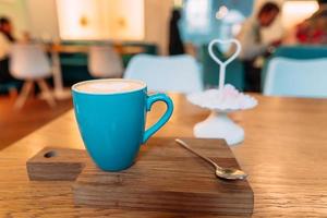 varm cappuccino kaffe i kaffe affär på trä- tabell foto