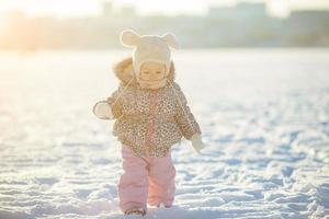 liten flicka promenader i de snö foto