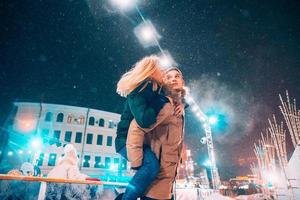 glad och lekfull par i värma vinter- klädespersedlar är lurar runt om foto