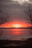 skön kall soluppgång över en frysta sjö foto