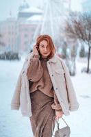 kvinna utanför på snöar kall vinter- dag foto