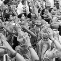 delhi, Indien april 03 2022 - kvinnor med kalash på huvud under jagannath tempel mangal kalash yatra, indisk hindu anhängare bära lergods kastruller som innehåller helig vatten med kokos på topp-svart och vit foto