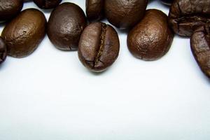 de sätt kaffe bönor lägga på en vit bakgrund, elegant och utsökt kaffe bönor och de arom av morgon- kaffe. foto