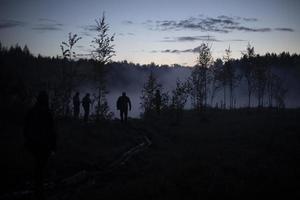 man i dimma på sjö. tidigt morgon- i skogen. foto