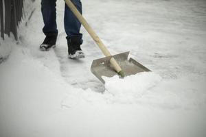 skyffel snöröjning. verktyg för rengöring av snödriva. vaktmästaren rensar vägen från nederbörd. foto