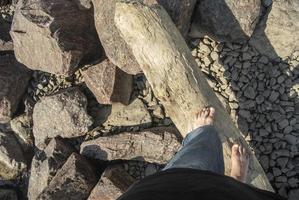 kille promenader barfota på vild strand. fötter på logga. foto