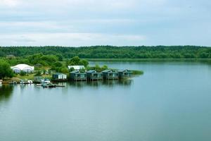 små trä- hus på de flod på en molnig dag foto