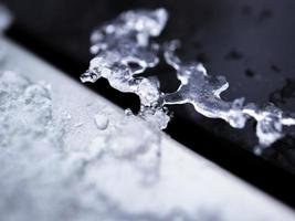 smältande snö formning ett is form på en svart och silver- bil yta foto