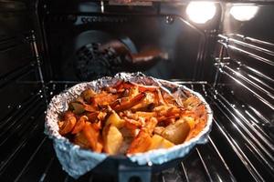 bakad potatisar med morot och Övrig kryddor i rostning panorera. foto
