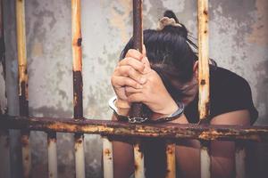 asiatisk kvinna i svart Sammanträde i en bur, varelse handbojor fråga för hjälp. de begrepp av straffa lagöverträdare. begrepp av sexuell våld och trakasserier, mänsklig människohandel. kopia Plats foto