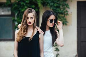 två skön ung flickor i klänningar foto