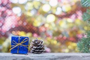 stänga upp av blå gåva låda och tallkotte på trä- tabell för jul eller ny år dekoration bakgrund foto