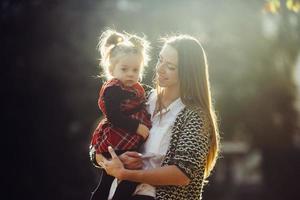 mor och liten dotter spelar i en parkera foto