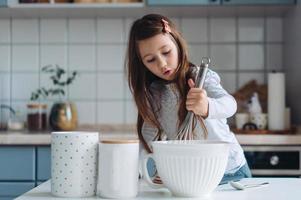 liten flicka kockar i de kök foto