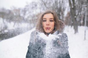skön ung kvinna slag snö foto